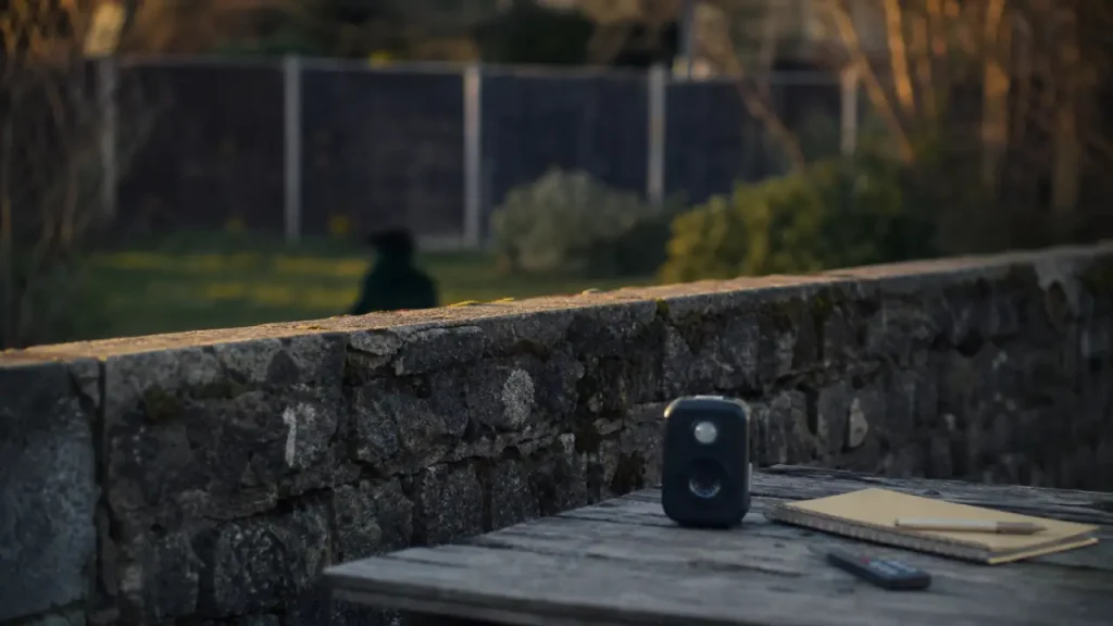 Ultrason pour chien du voisin : boîtier anti-aboiement près du mur mitoyen, jardin flou